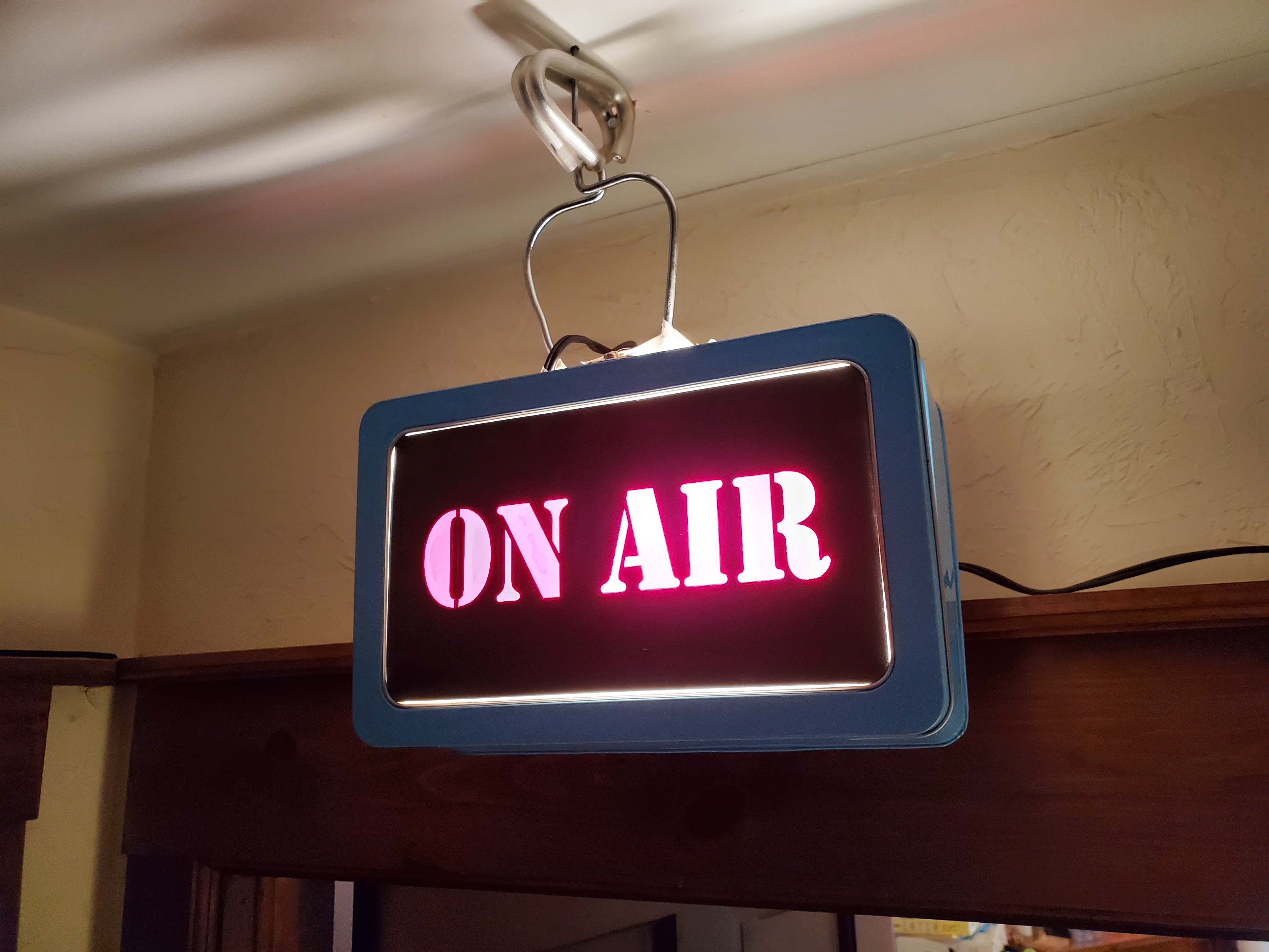 Shows a make-shift 'on-air' light of the kind you would find in a news radio booth to indicate the host is live on air.